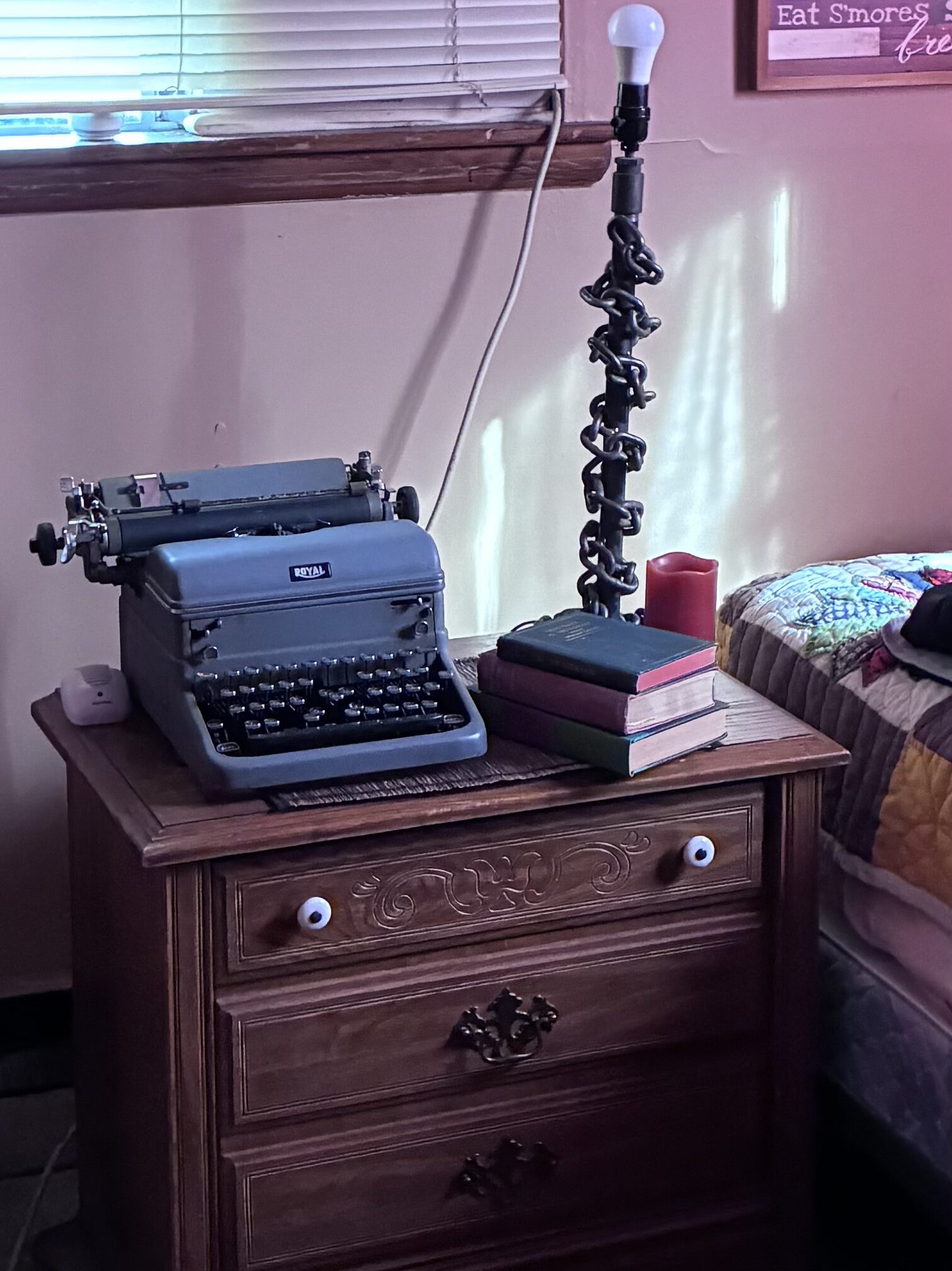 Vintage Royal typewriter on an antique nightstand in the cabin bedroom.